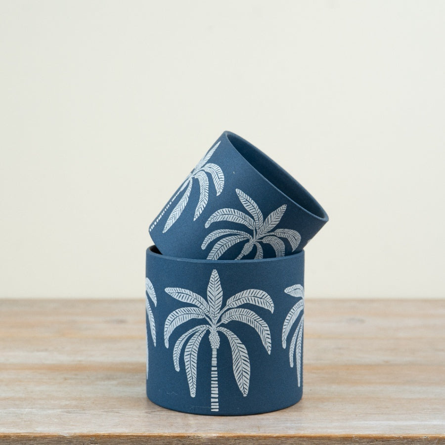 a Large and small Palm tree bluw flower pot stacked on a shelf
