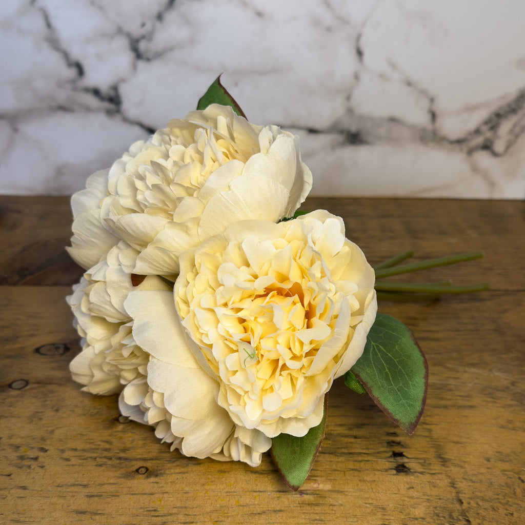 Bouquet of peony flowers on a wooden surface with a marble background