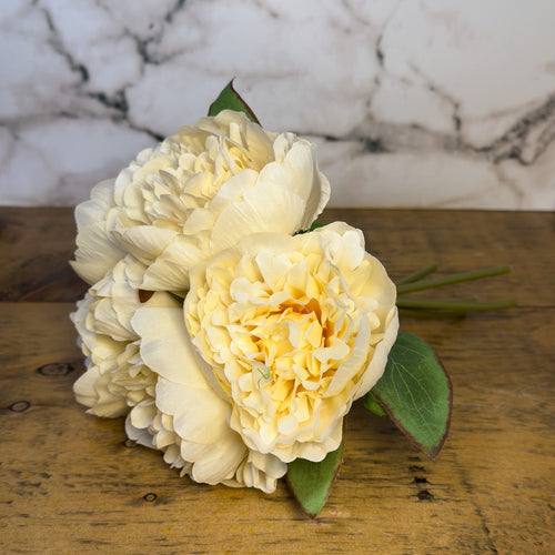 Bouquet of peony flowers on a wooden surface with a marble background