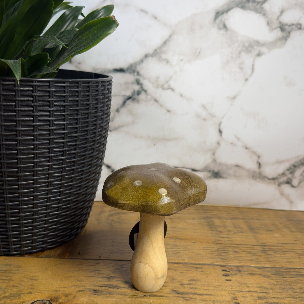 Wooden mushroom decor on a wooden surface with a marble wall in the background
